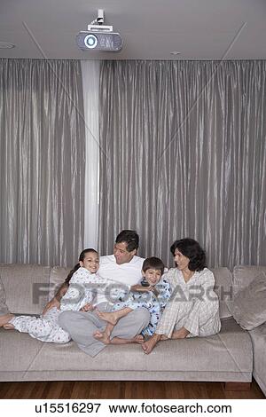 Parents with two children watching TV View Large Photo Image Stock Photo - Parents with two children watching TV. Fotosearch