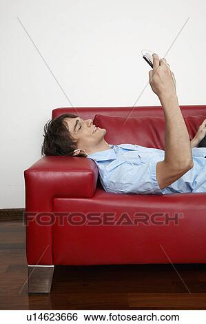 Young Man Using Mobile Phone on Sofa View Large Photo Image Stock Photograph - Young Man Using Mobile Phone on Sofa. Fotosearch