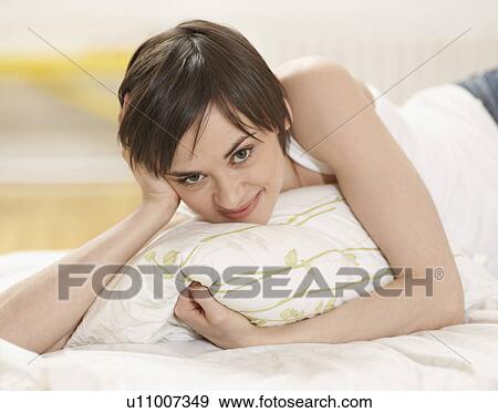 Stock Photo - Young Woman Lying in Bed. Fotosearch