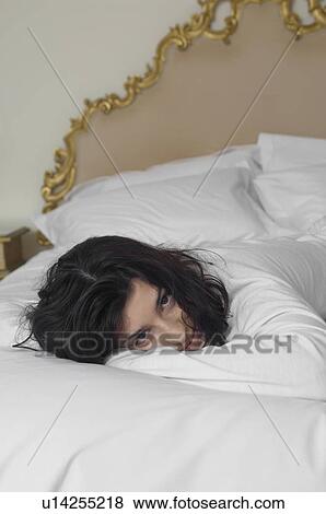 Young woman lying on bed (portrait) View Large Photo Image Stock Photo - Young woman lying on bed (portrait). Fotosearch