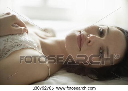 Young woman lying on bed View Large Photo Image Stock Photography - Young woman lying on bed. Fotosearch