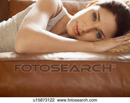Young woman lying on sofa View Large Photo Image Stock Image - Young woman lying on sofa. Fotosearch