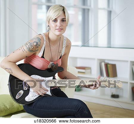 Stock Photograph - Young Woman Playing Electric Guitar. Fotosearch