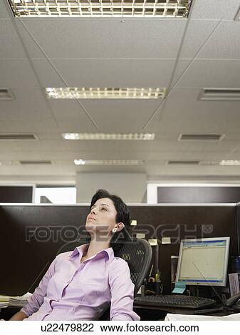 Tired office worker sitting at desk View Large Photo Image Stock Image - Tired office worker sitting at desk. Fotosearch