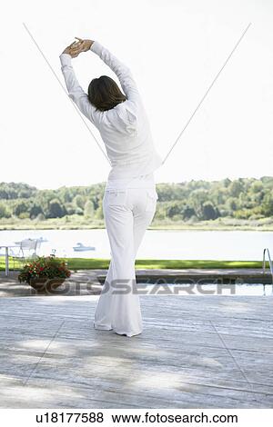Stock Photo - Woman stretching on deck. Fotosearch