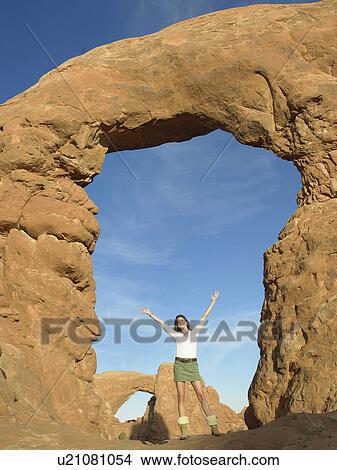 Young woman standing under arched rock View Large Photo Image Picture - Young woman standing under arched rock. Fotosearch
