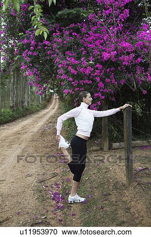 Young woman stretching on dirt road View Large Photo Image Stock Image - Young woman stretching on dirt road. Fotosearch