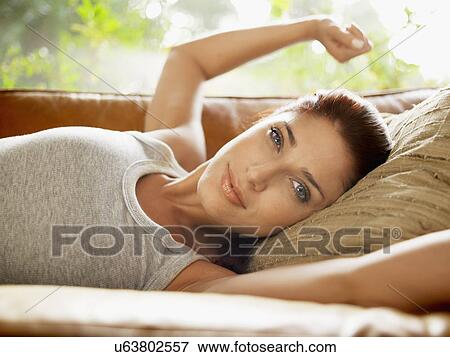 Young woman waking up on sofa View Large Photo Image Stock Photo - Young woman waking up on sofa. Fotosearch