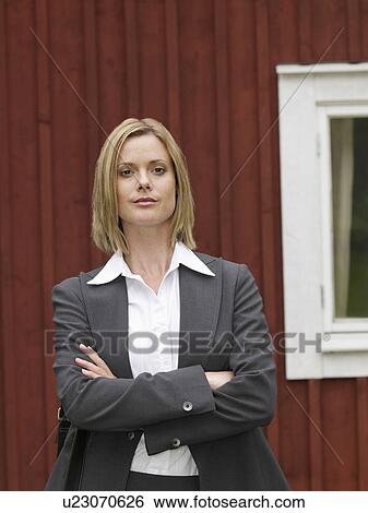 Stock Photograph - Businesswoman by country cottage. Fotosearch