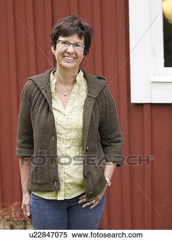 Middle aged woman by country cottage View Large Photo Image Stock Photography - Middle aged woman by country cottage. Fotosearch