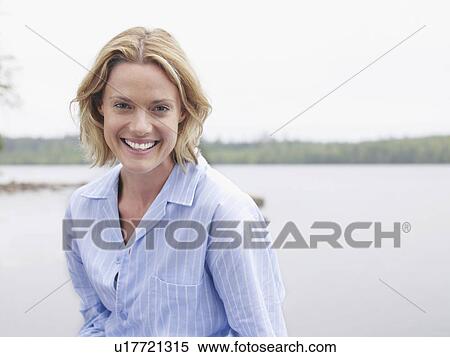 Stock Photography - Woman laughing outdoors by the water.. Fotosearch