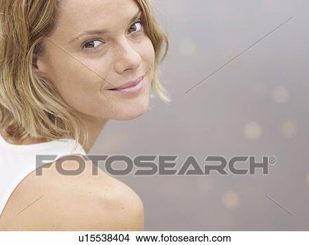 Woman sitting by the water smiling. View Large Photo Image Picture - Woman sitting by the water smiling.. Fotosearch
