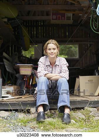 Woman sitting in shed smiling. View Large Photo Image Stock Photo - Woman sitting in shed smiling.. Fotosearch