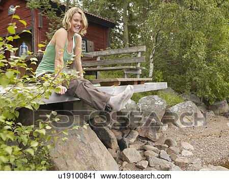 Woman sitting on dock smiling. View Large Photo Image Stock Image - Woman sitting on dock smiling.. Fotosearch
