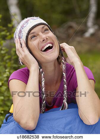 Woman sitting with a sleeping bag around waist laughing. View Large Photo Image Stock Photo - Woman sitting with a sleeping bag around waist laughing.. Fotosearch