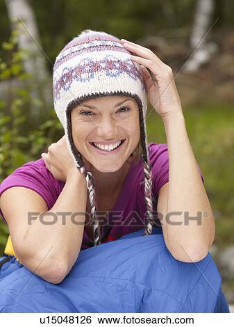 Woman sitting with a sleeping bag around waist smiling. View Large Photo Image Stock Photograph - Woman sitting with a sleeping bag around waist smiling.. Fotosearch