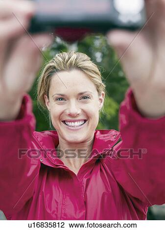 Woman taking self-portrait outdoors. View Large Photo Image Stock Image - Woman taking self-portrait outdoors.. Fotosearch