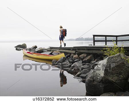Woman walking on a dock near a boat. View Large Photo Image Stock Image - Woman walking on a dock near a boat.. Fotosearch