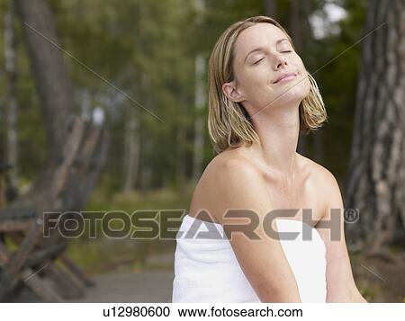 Woman wearing towel with eyes closed outdoors smiling. View Large Photo Image Stock Image - Woman wearing towel with eyes closed outdoors smiling.. Fotosearch