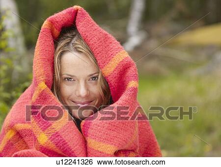 Woman with blanket wrapped around her smiling. View Large Photo Image Stock Photograph - Woman with blanket wrapped around her smiling.. Fotosearch