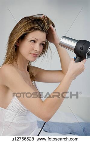 Portrait of a woman using a hairdryer. View Large Photo Image Stock Photo - Portrait of a woman using a hairdryer.. Fotosearch