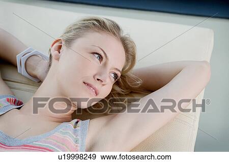 Stock Photo - Woman laying on sofa.. Fotosearch