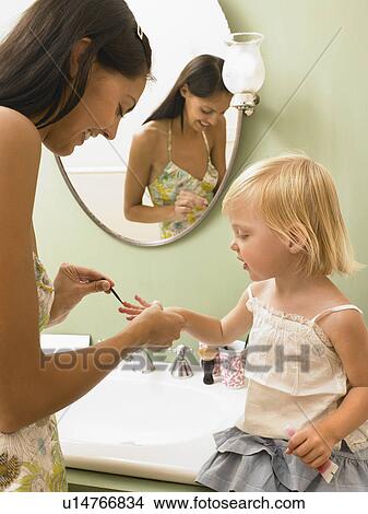 Mother and daughter applying makeup. View Large Photo Image Picture - Mother and daughter applying makeup.. Fotosearch