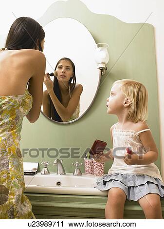 Stock Image - Mother and daughter applying makeup.. Fotosearch