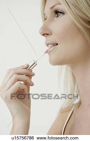 Woman putting on lip gloss. View Large Photo Image Stock Photograph - Woman putting on lip gloss.. Fotosearch
