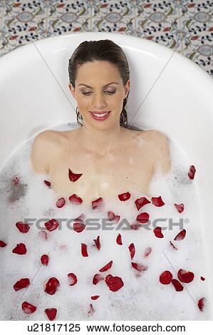 young woman lying in bath with lather and rose petals, overhead view View Large Photo Image Stock Photography - young woman lying in bath with lather and rose petals, overhead view. Fotosearch