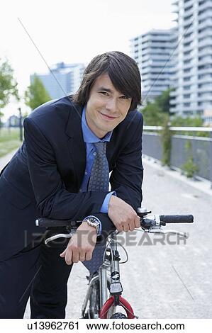 Businessman in park resting on bike smiling portrait. View Large Photo Image Stock Image - Businessman in park resting on bike smiling portrait.. Fotosearch