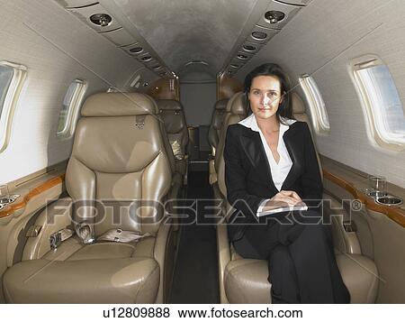 Stock Photo - Businesswomen seated in a private jet.. Fotosearch