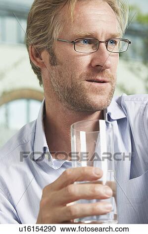 Stock Image - Close-Up portrait of Businessman drinking glass of water.. Fotosearch