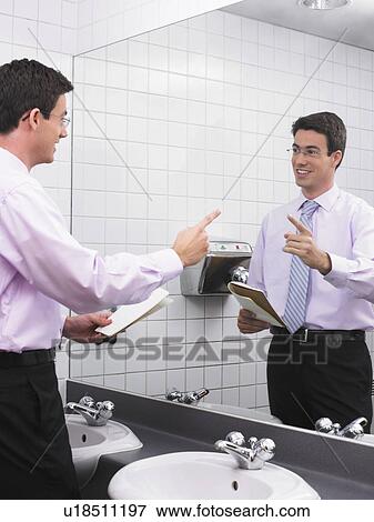 Man practicing speech in office washroom mirror View Large Photo Image Stock Photo - Man practicing speech in office washroom mirror. Fotosearch