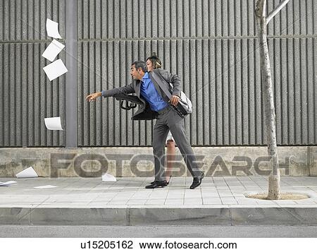 Older man and young woman chasing papers blown by the wind down the pavement, Alicante, Spain, View Large Photo Image Stock Image - Older man and young woman chasing papers blown by the wind down the pavement, Alicante, Spain,. Fotosearch