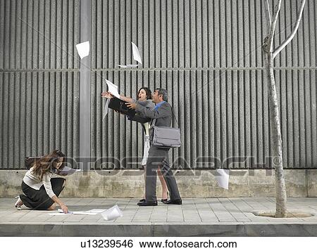 Older man and young woman chasing papers blown by the wind down the sidewalk, being helped by another woman, Alicante, Spain, View Large Photo Image Stock Photograph - Older man and young woman chasing papers blown by the wind down the sidewalk, being helped by another woman, Alicante, Spain,. Fotosearch