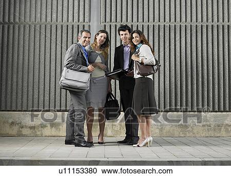 Two businesswomen and two businessmen standing in a semi circle looking at camera by concrete wall, Alicante, Spain, View Large Photo Image Stock Image - Two businesswomen and two businessmen standing in a semi circle looking at camera by concrete wall, Alicante, Spain,. Fotosearch