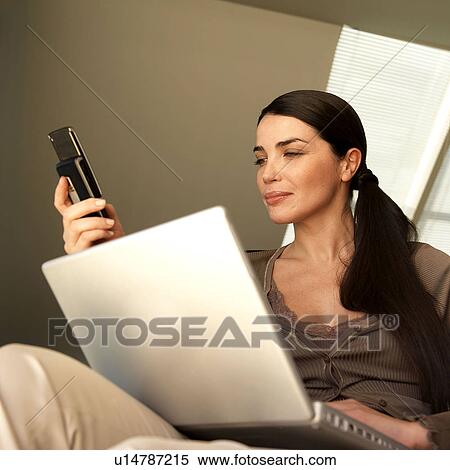 Woman with laptop and phone View Large Photo Image Stock Photography - Woman with laptop and phone. Fotosearch