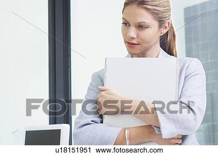 Stock Image - Young Business woman in office with file.. Fotosearch