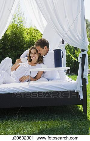 Couple having breakfast on bed in garden View Large Photo Image Stock Image - Couple having breakfast on bed in garden. Fotosearch