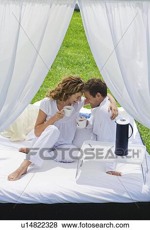 Couple having breakfast on bed in garden View Large Photo Image Stock Photo - Couple having breakfast on bed in garden. Fotosearch