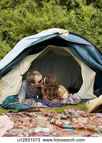Stock Image - Man and woman lying inside tent. Fotosearch