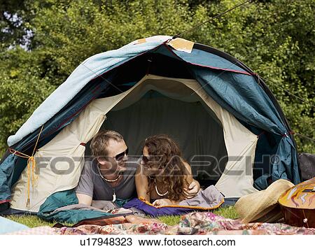 Stock Image - Man and woman lying inside tent. Fotosearch