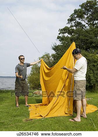 Stock Photograph - Men having problems setting up a tent. Fotosearch