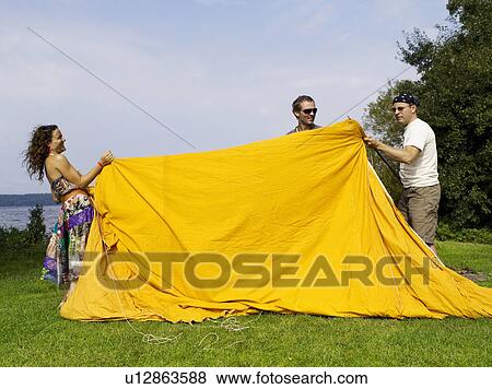 Three people setting up a tent View Large Photo Image Stock Photo - Three people setting up a tent. Fotosearch