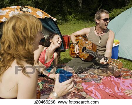Stock Photo - Three people singing together at camp. Fotosearch