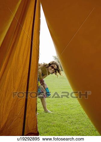 Stock Photography - Woman looking into tent. Fotosearch