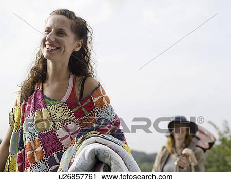 Woman smiling with blanket on arm View Large Photo Image Stock Image - Woman smiling with blanket on arm. Fotosearch