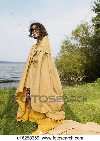 Stock Photo - Woman trying to set up a tent. Fotosearch
