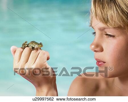 Stock Image - Boy holding a frog in his hand.. Fotosearch